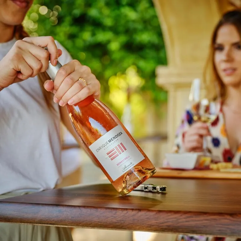 Een glas rosé wordt ingeschonken tijdens een lunch op een terras